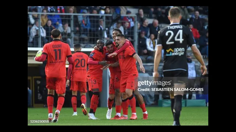 Cầu thủ Nice với áo đỏ đang cố gắng chặn đường tiền vệ Angers trong trận đấu bóng đá.